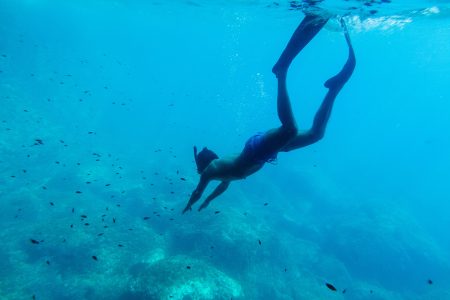 man swim underwater in snorkel. Male swimming in blue sea lagoon